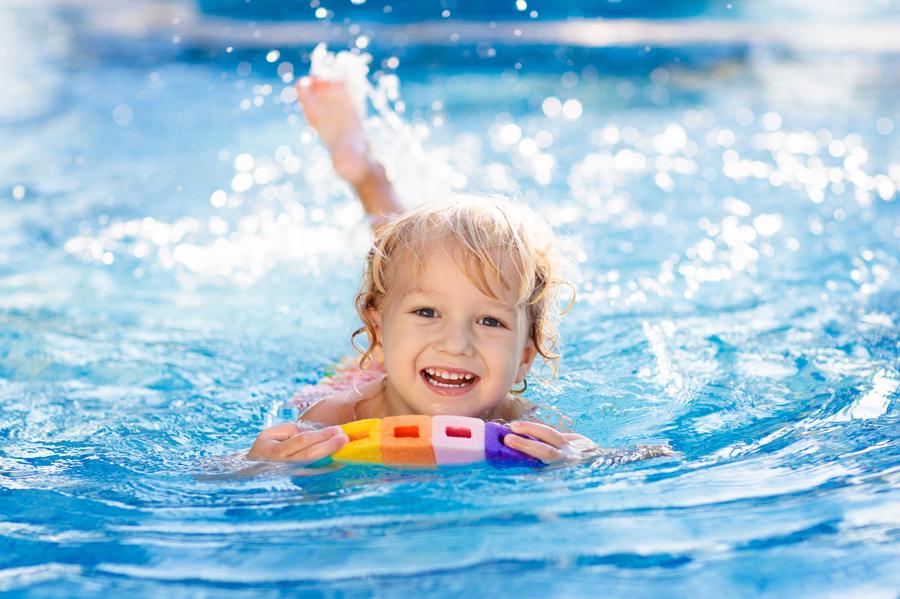 A young swimmer practising with a float in the pool